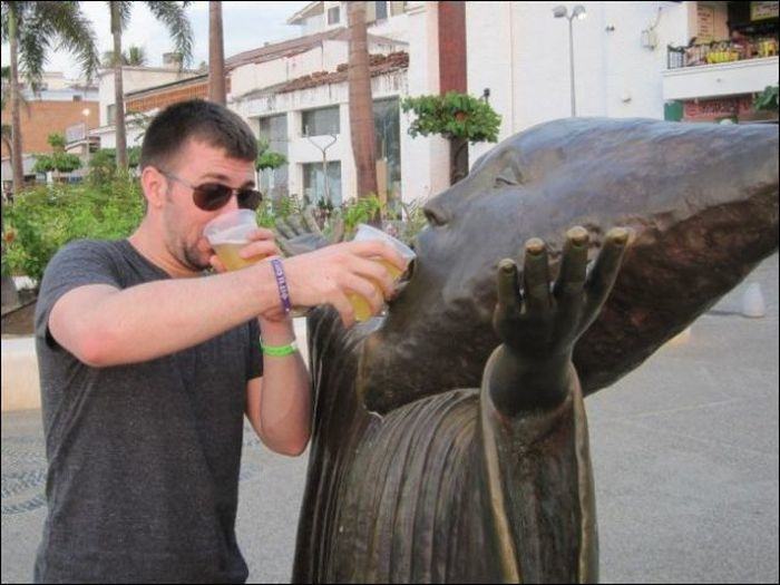 compartiendo la cerveza a una estatua