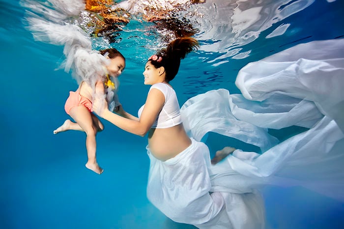 mujer embarazada bajo el agua con su hijo