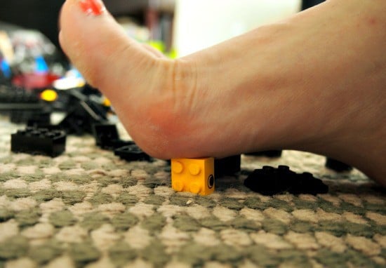 Pie sobre figuras de lego en el suelo 