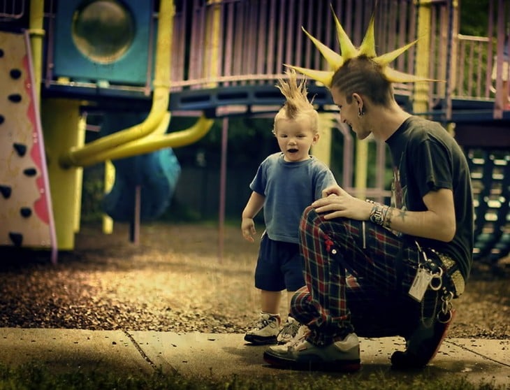 Padre e hijo en un parque con el mismo peinado 