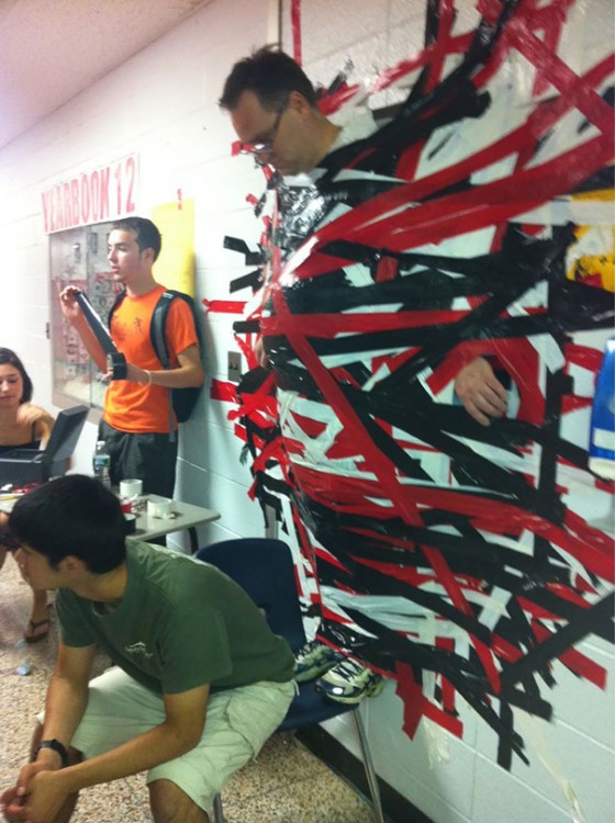 maestro pegado en la pared con cintas por sus alumnos con la finalidad de donación