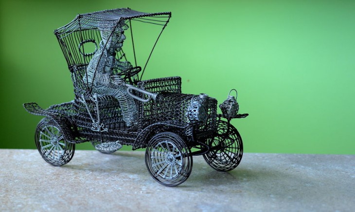 Escultura de alambre con forma de un carrito con un chofer 