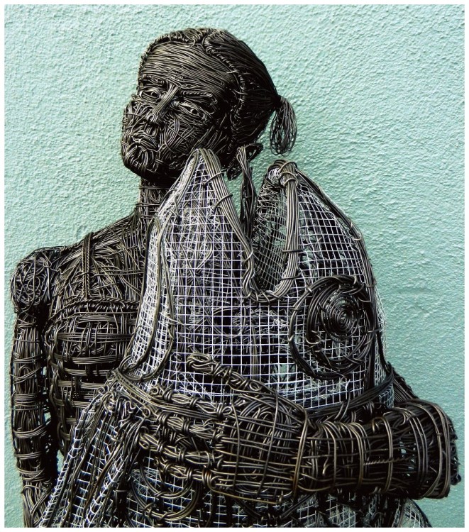 Escultura de alambre de una chica con un pescado en la mano por Zak Gere 