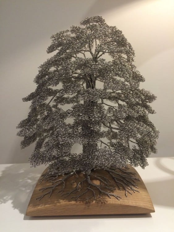 Escultura hecha de alambre formando un árbol 