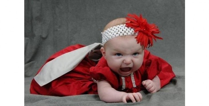 bebé  vestida de rojo y gritando