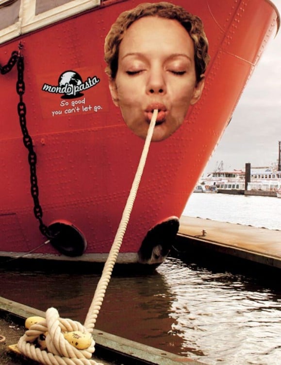 Cara de una mujer en un barco que simula que esta comiendo pasta