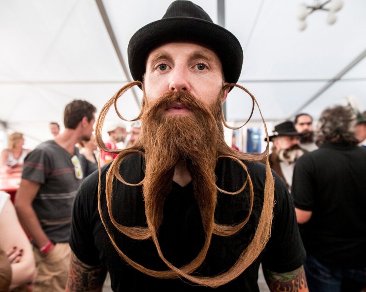 fotografía de un chico con una barba y bigote demasiado largo y un increíble diseño hecho con ella 