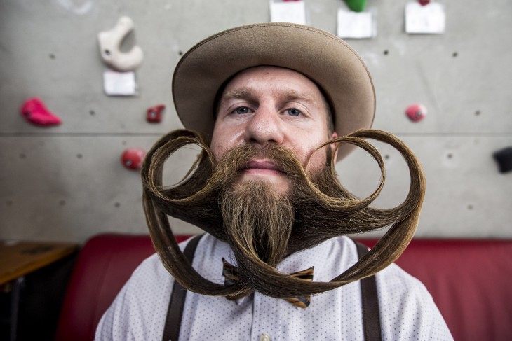 Chico con un sombrero y una barba y bigote peinado en el Campeonato Mundial de Barba y Bigote 