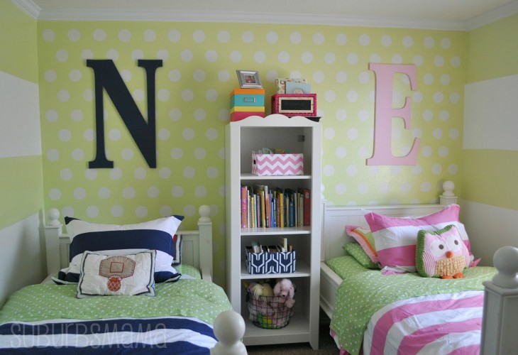 habitación con dos camas divididas por un mueble y con las iniciales N y E 