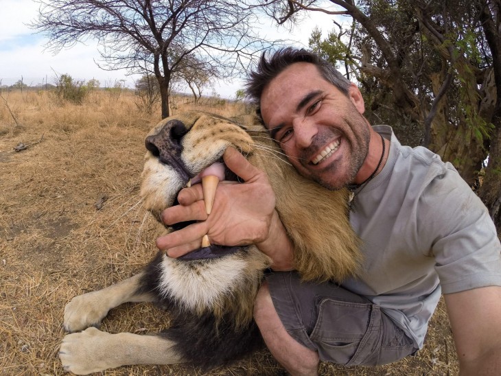 selfie de un hombre junto a un león