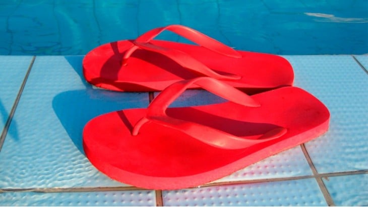 sandalias en color rojo a la orilla de una alberca 