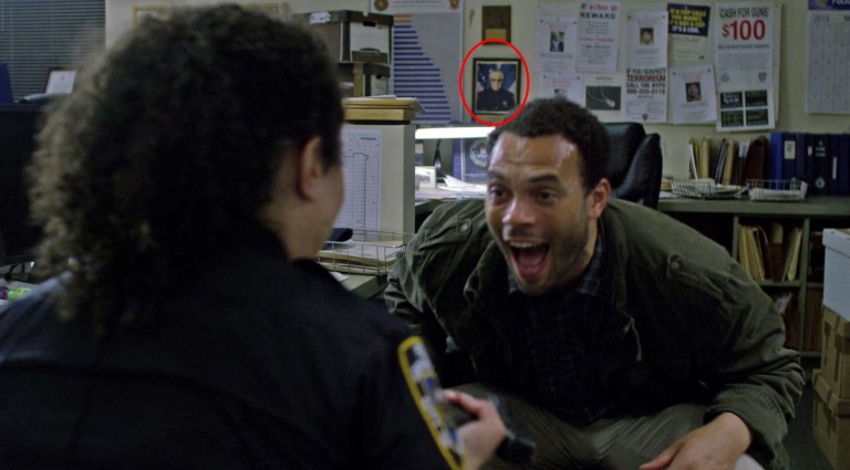 Escena de un capítulo de la serie de Jessica Jones en donde sale un cuadro con la cara de Stan Lee en la pared