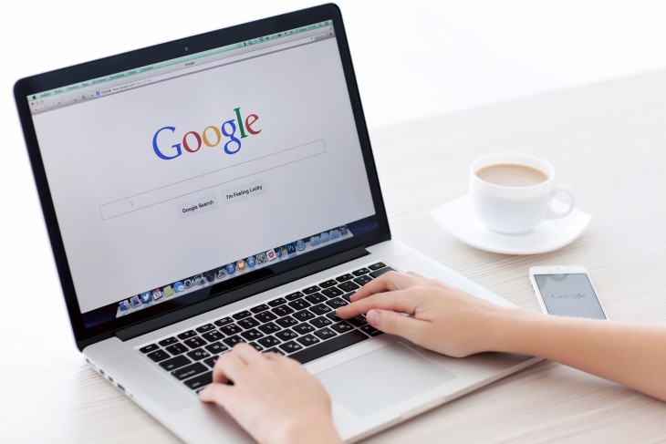 manos de una persona sobre una laptop a punto de hacer una búsqueda en Google