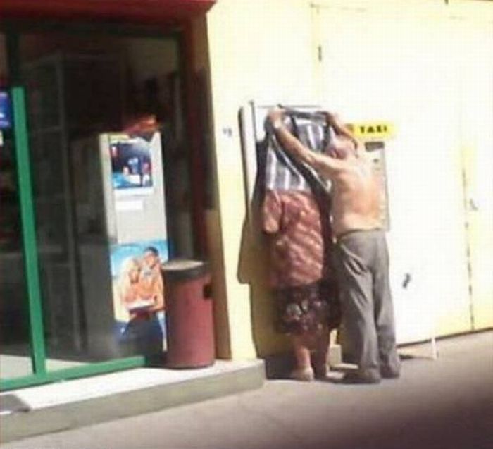 hombre se quita su camisa para evitar que alguien vea la pantalla del cajero