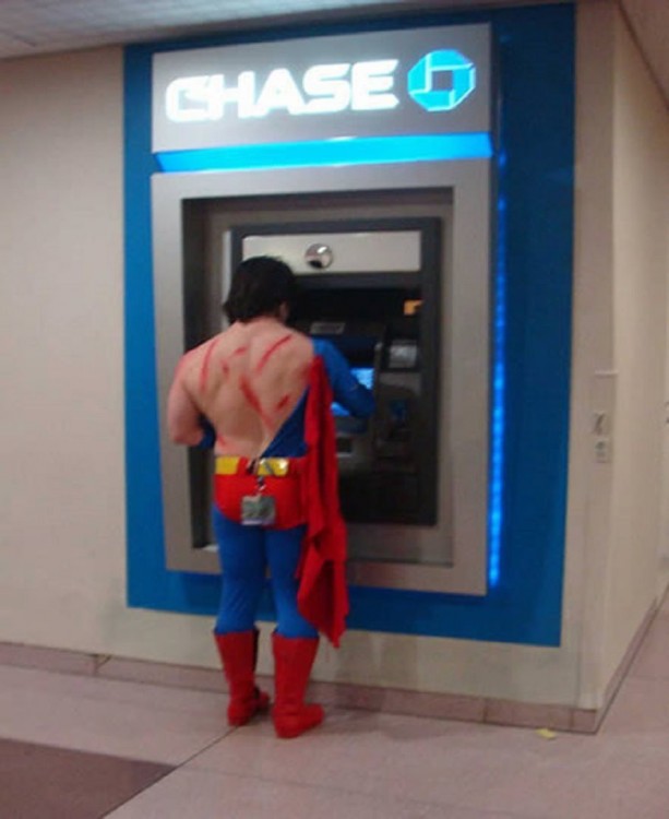 Spiderman con el traje rasgado retirando efectivo