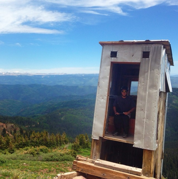 hombre sentado en un baño sobre la montaña en Colorado