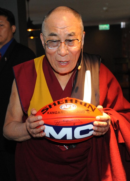 DALAILAMA CON UN BALÓN DE FUTBOL AMERICANO AUTOGRAFIADO EN LAS MANOS 