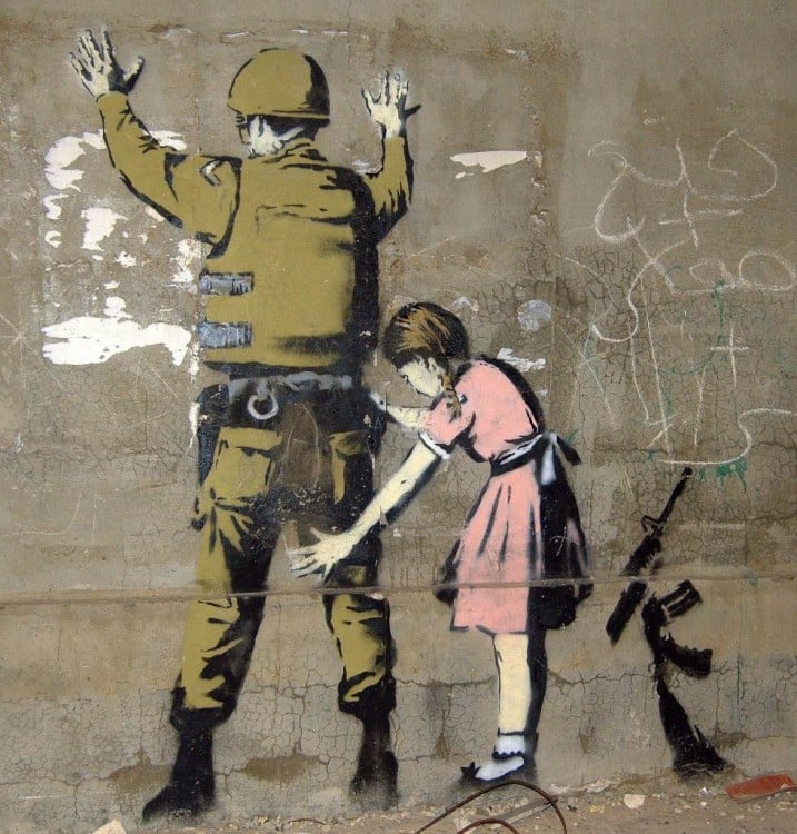 Obra urbana de Bansky donde una niña revisando a un soldado 