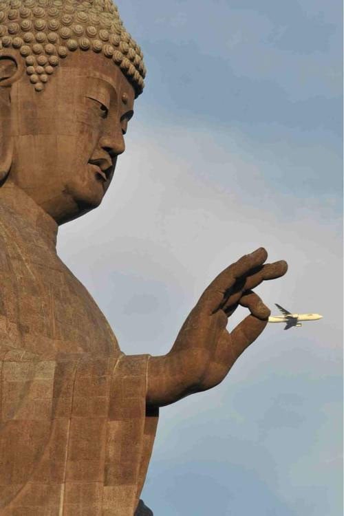 Estatua de un buda que parece sostener un avión en la mano 