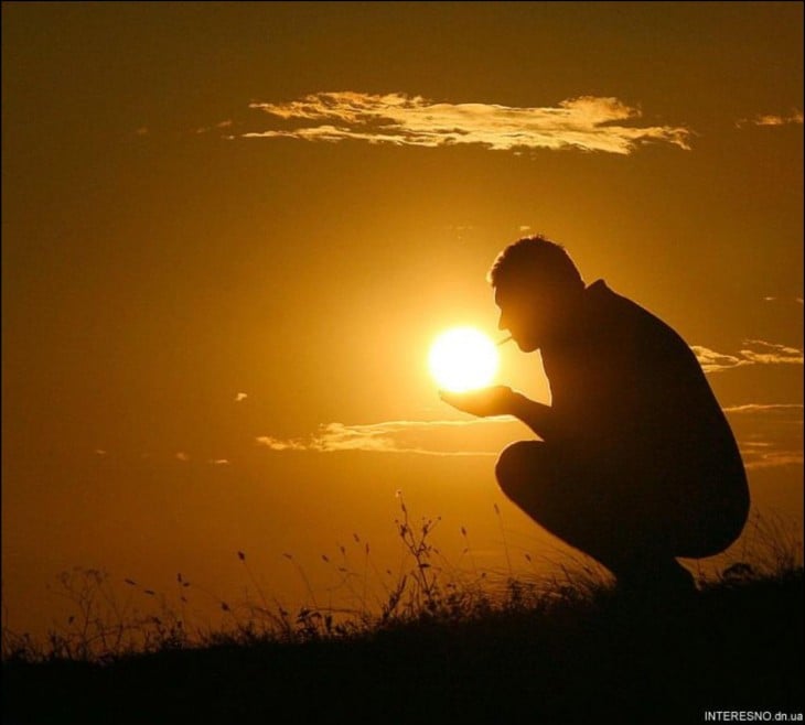 imagen de un hombre que simula estar encendiendo un cigarro con el sol 