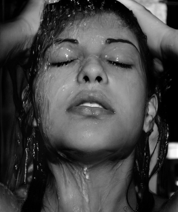 fotografía de la cara de una chica que esta mojada con agua 
