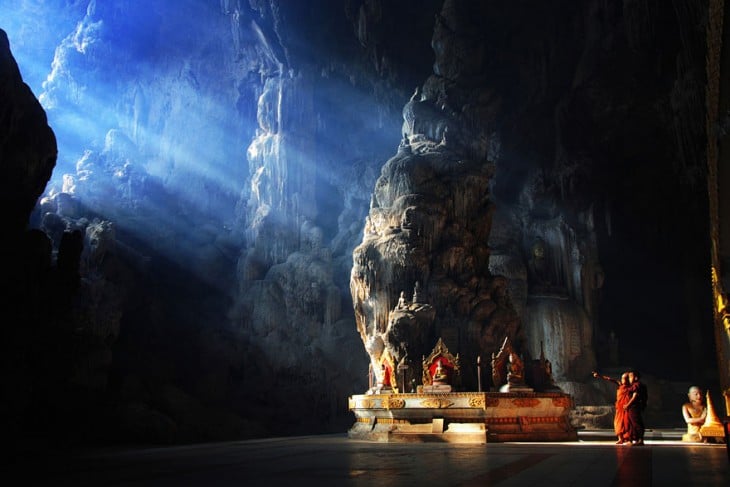 Monjes dentro de la caverna marina Kyautt en Tailandia 