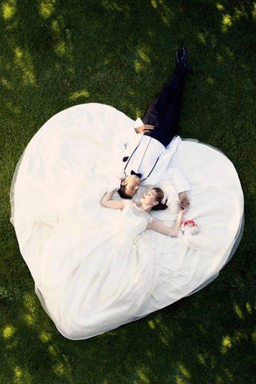 novios acostados y un vestido en forma de corazon