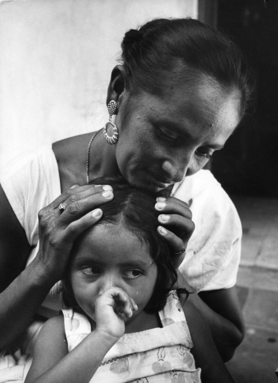 Mujer con sus manos en la cabeza de su hija 