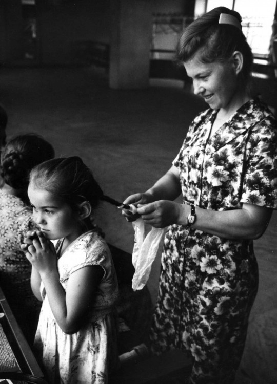 madre haciendo una trenza en el cabello de su hija 