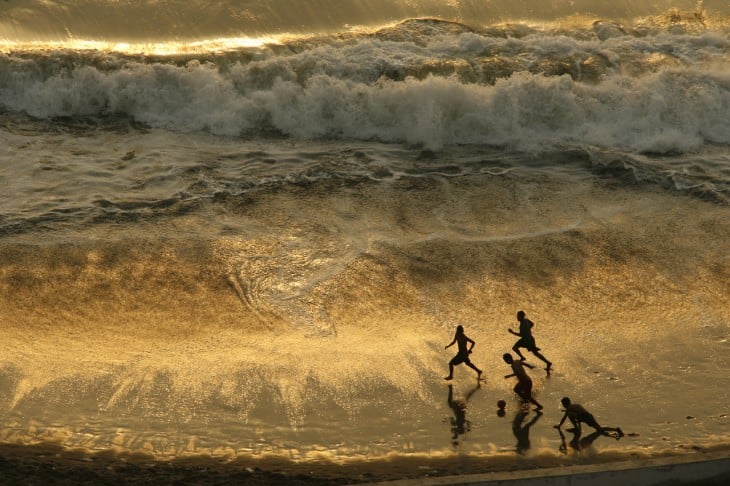 Niños jugando al futbol al atardecer en Lima, Perú