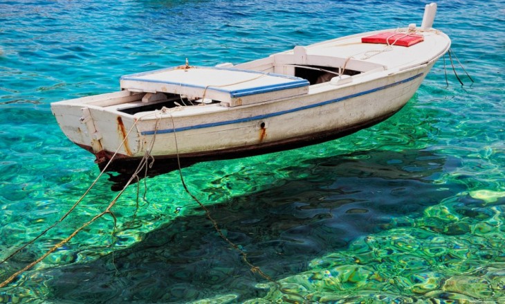 bote flotando sobre el agua clara de Primosten en Croacia 