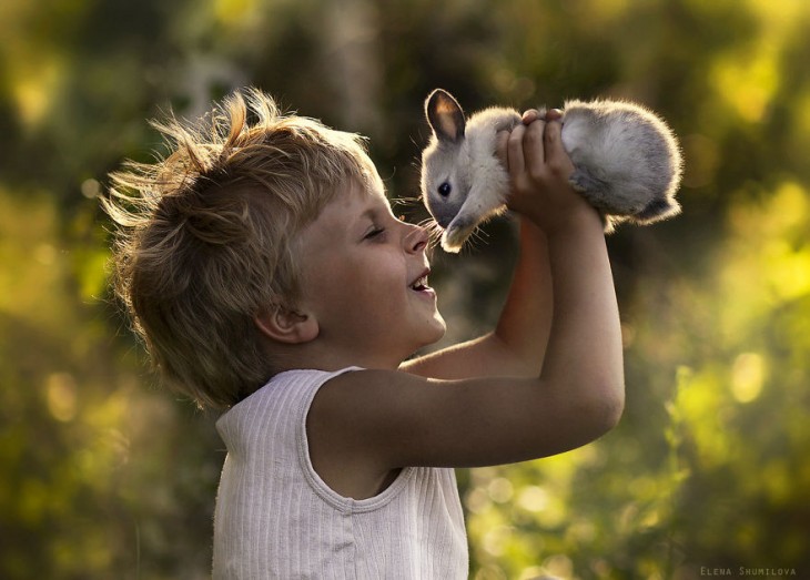 niño alegre sujetando a su conejo