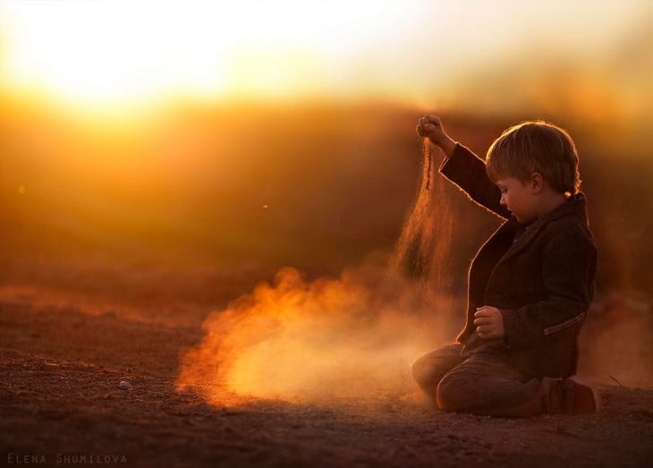 niño jugando en el atardecer con tierra