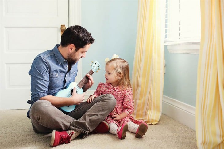 PADRE TOCANDO LA GUITARRA PARA SU HIJA