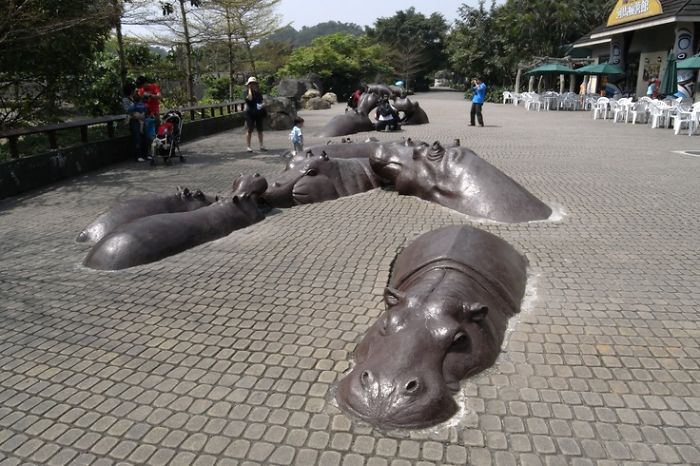 escultura de Hipopótamos saliendo de la calle en China