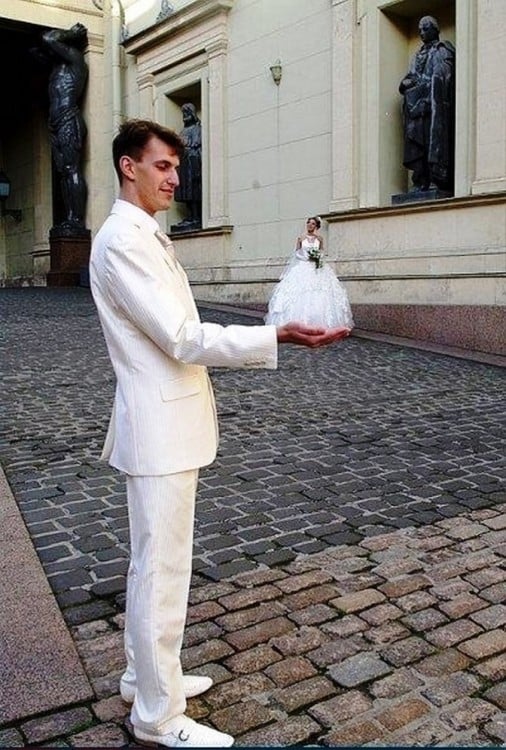 novio vestido de blanco sosteniendo a novia de blanco