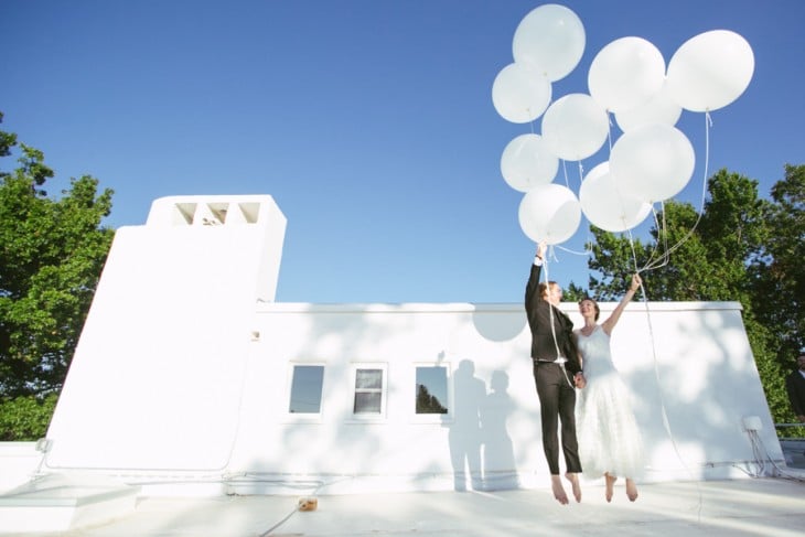 novios jugando con globos blancos