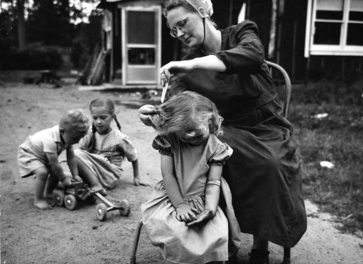 madre peinando a sus tres hijas