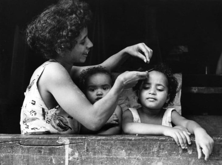 madre peinando a sus dos hijas