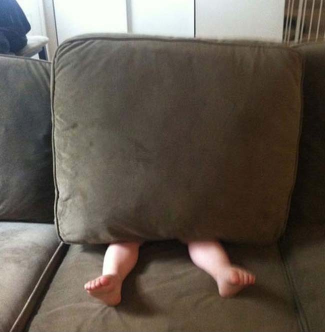 niño escondiéndose debajo del sillon