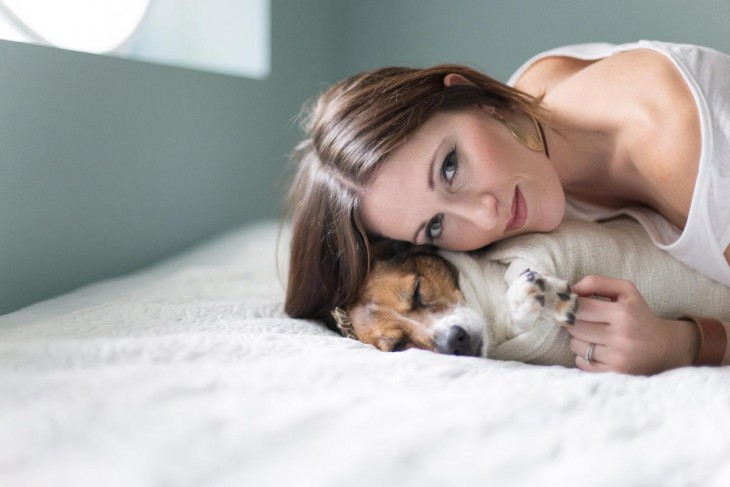 mujer en a cama con su perro