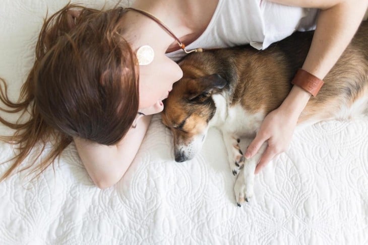 mujer y perro durmiendo en la cama