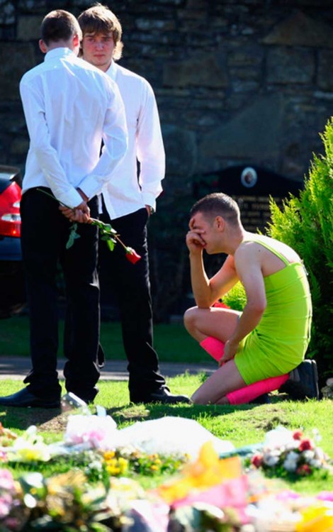 chico con vestido hincado en el suelo llorando en el funeral de su mejor amigo 