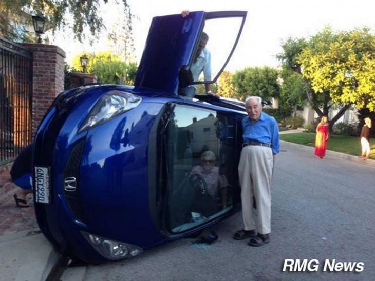 Fotografía de un accidente de automóvil con una mujer anciana dentro y un anciano fuera del coche 