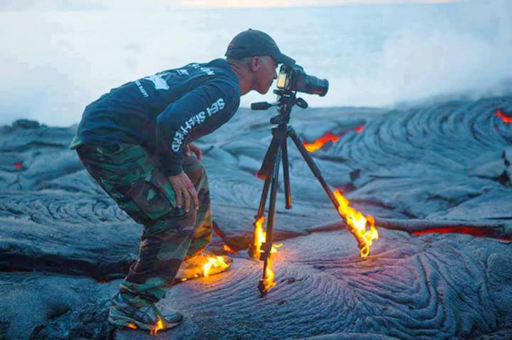 Fotógrafo con la cámara en llamas en un desierto 