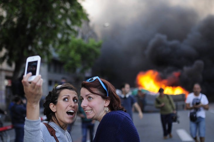 Selfie de dos chicas durante una explosión detrás de ellas 