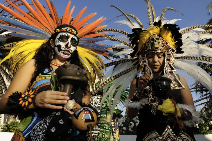 Personas disfrazadas de indigenas Aztecas, celebran el día de los muertos