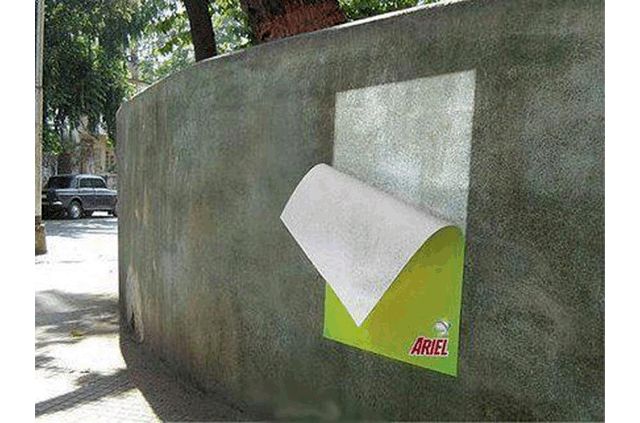 publicidad de jabon en polvo ariel, cartel sobre un muro blanqueado