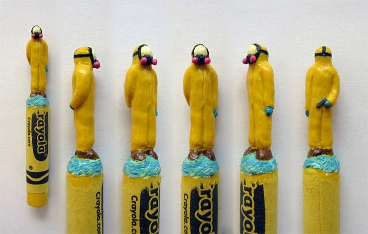 Esculturas de unos hombres vestidos de amarillo sobre unas crayolas 
