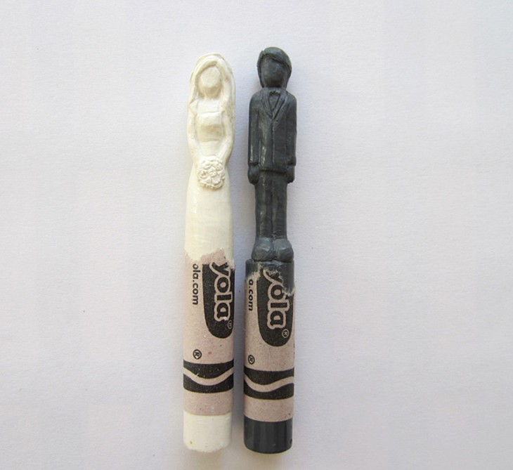 Escultura de una pareja de esposos sobre dos crayolas 